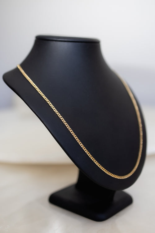 Angled view of the 18ct solid gold handmade Cuban link chain showing its depth and polish