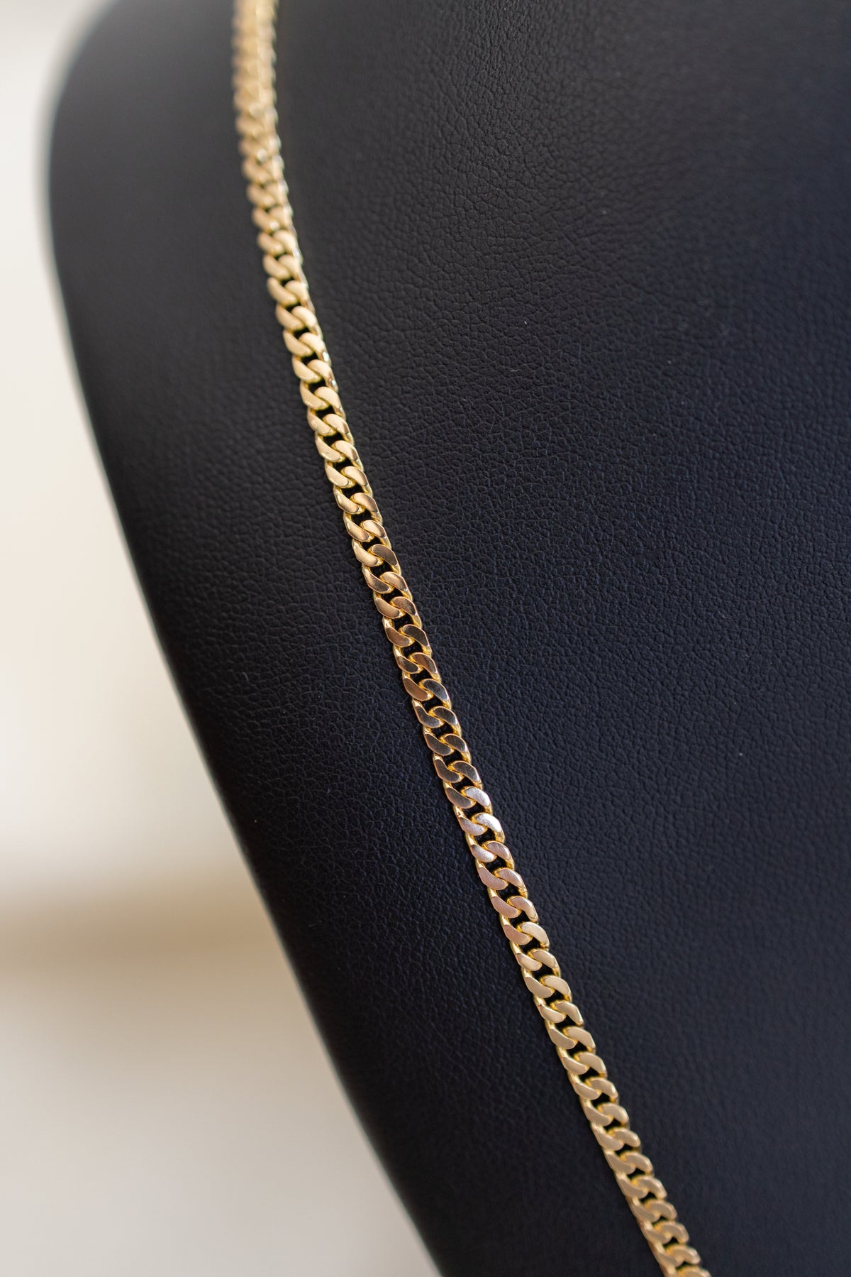 Macro close-up showing the hand-finished link edges of the 18ct gold Cuban chain