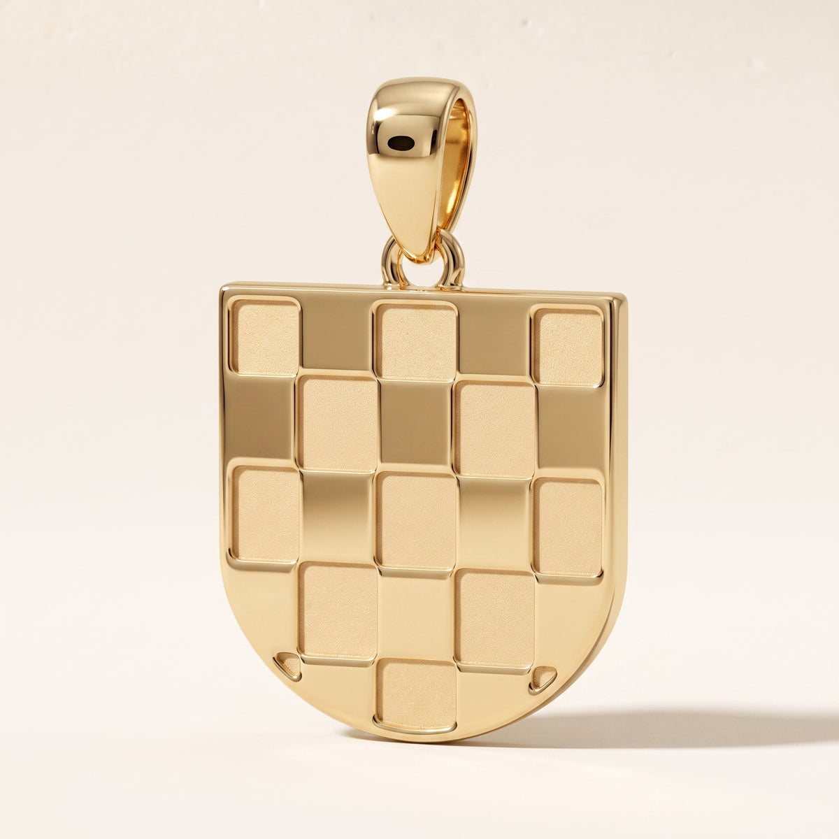 Bijelo Prvo GRB pendant in 9ct yellow gold, angled view showing the thickness of the shield