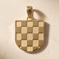 Bijelo Prvo GRB pendant in 9ct yellow gold resting on pale travertine stone