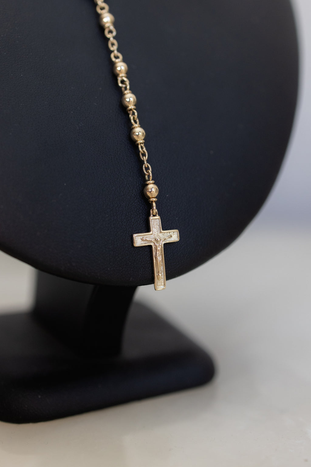 Close-up of the 9ct gold crucifix hanging from the rosary necklace