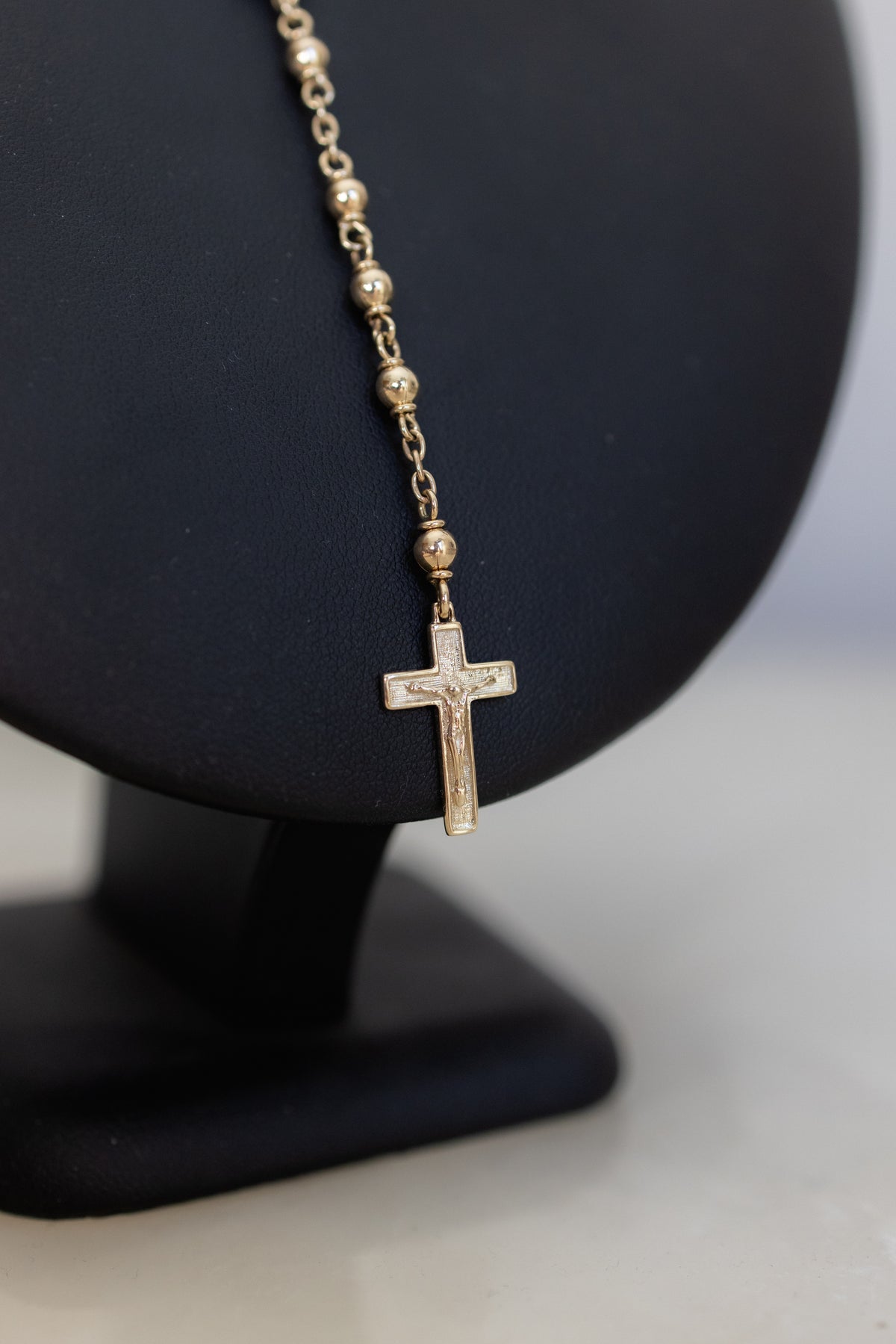 Close-up of the 9ct gold crucifix hanging from the rosary necklace