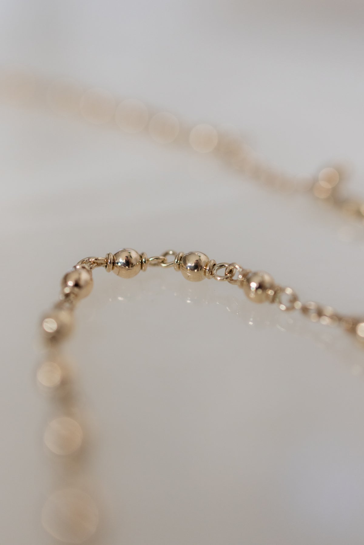 Macro detail of the round 4mm gold beads on the handmade 9ct gold rosary