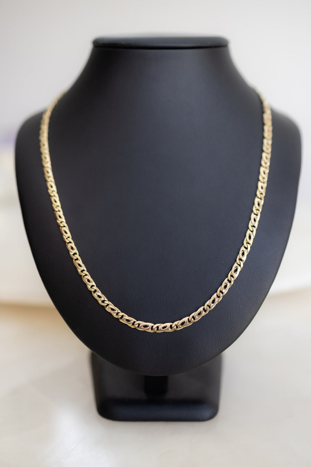 Handmade 4.5mm birdseye link chain in 9ct yellow gold on a display bust, front view