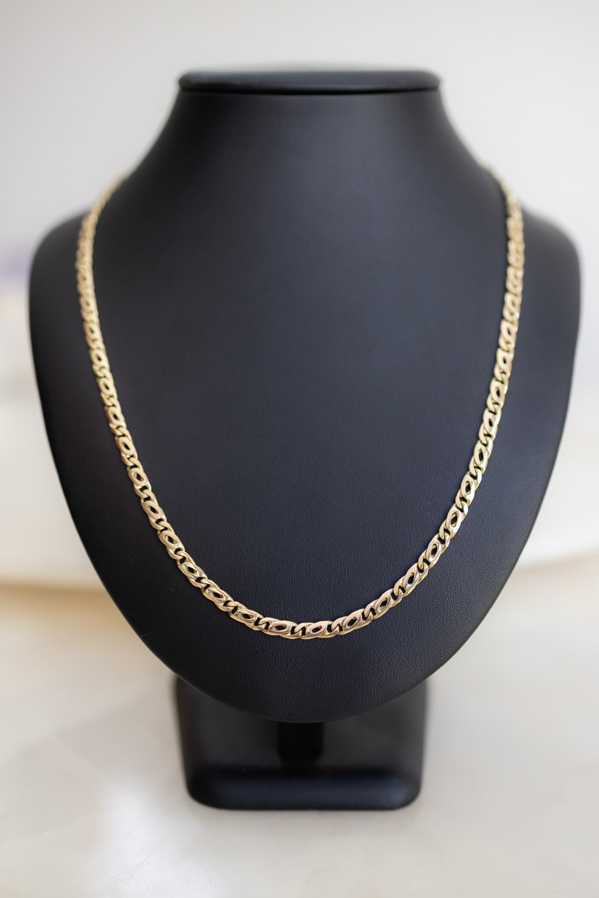 Handmade 4.5mm birdseye link chain in 9ct yellow gold on a display bust, front view