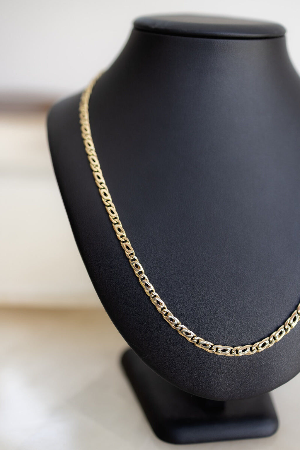 Handmade birdseye link chain 4.5mm in 9ct yellow gold, angled view on a bust