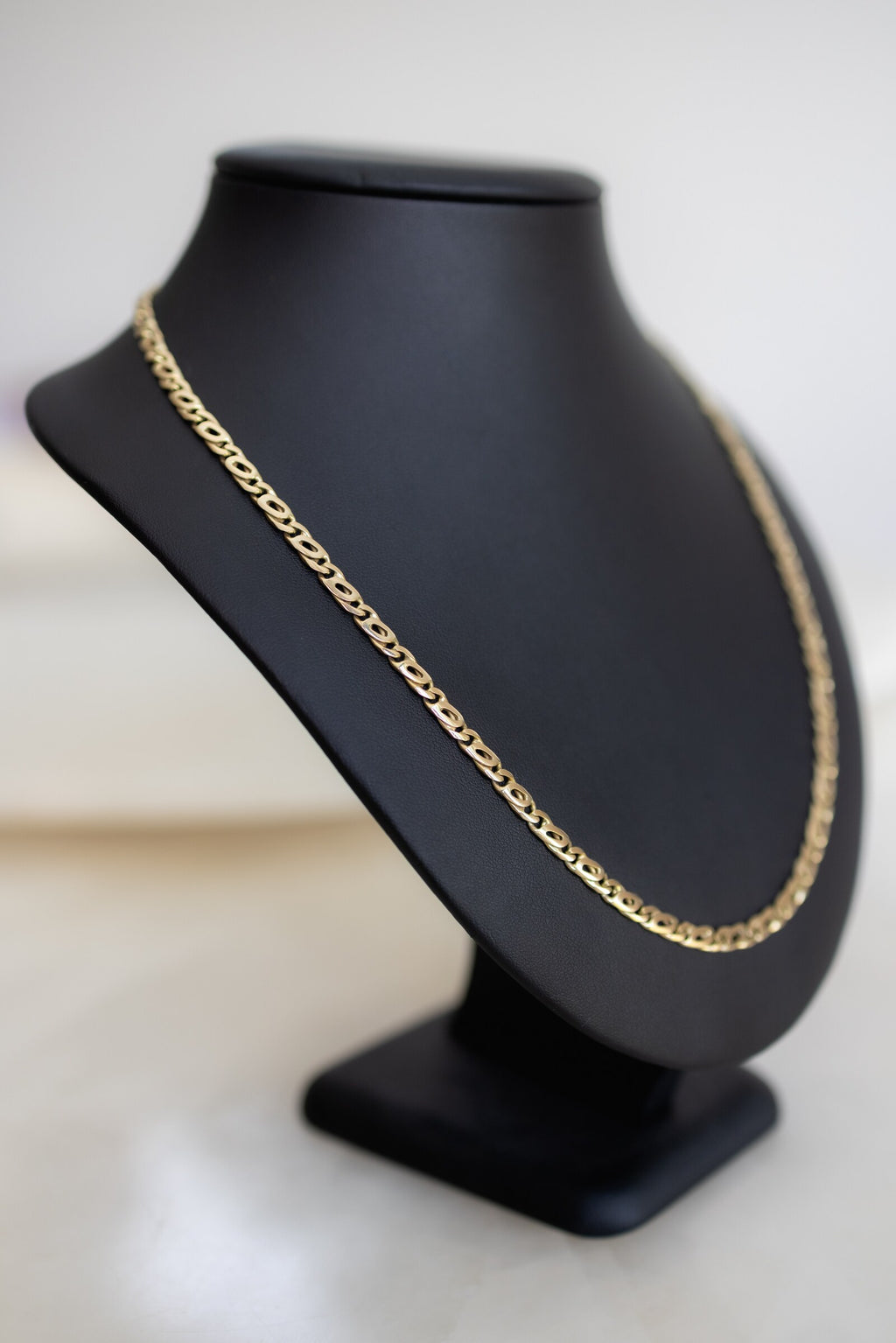 9ct yellow gold 4.5mm birdseye link chain seen from the side on a display bust