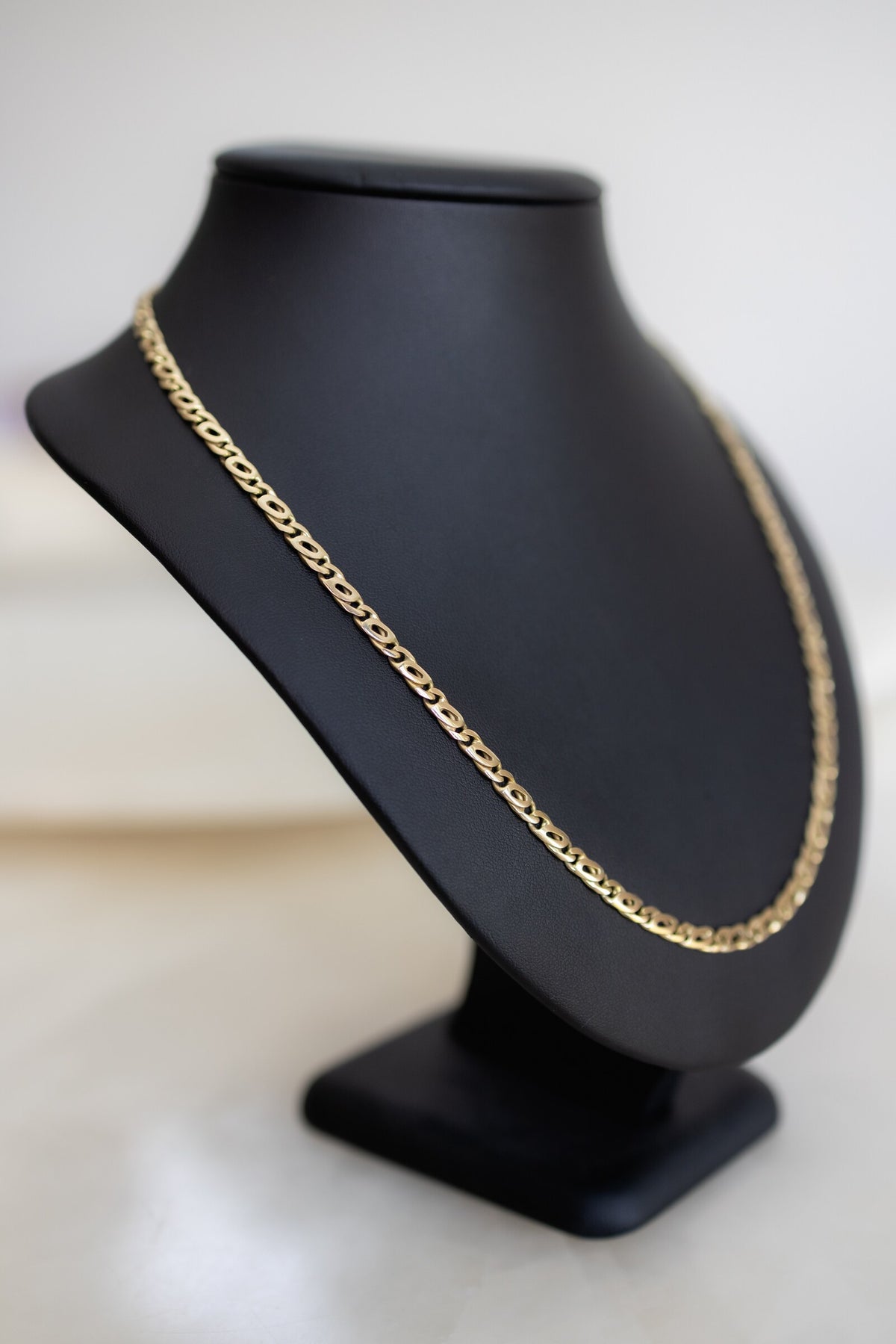 9ct yellow gold 4.5mm birdseye link chain seen from the side on a display bust