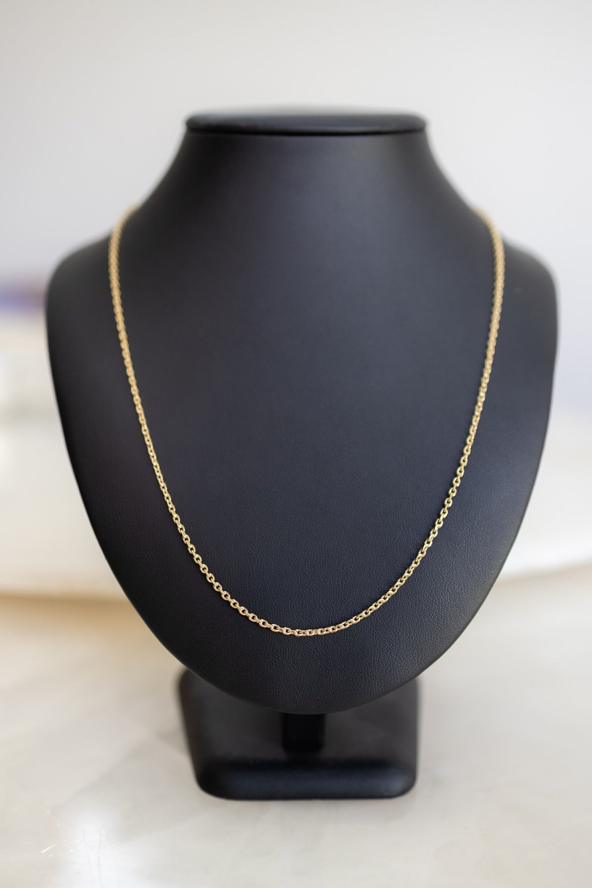 Handmade 1.7mm cable chain in 9ct yellow gold on a display bust, front view