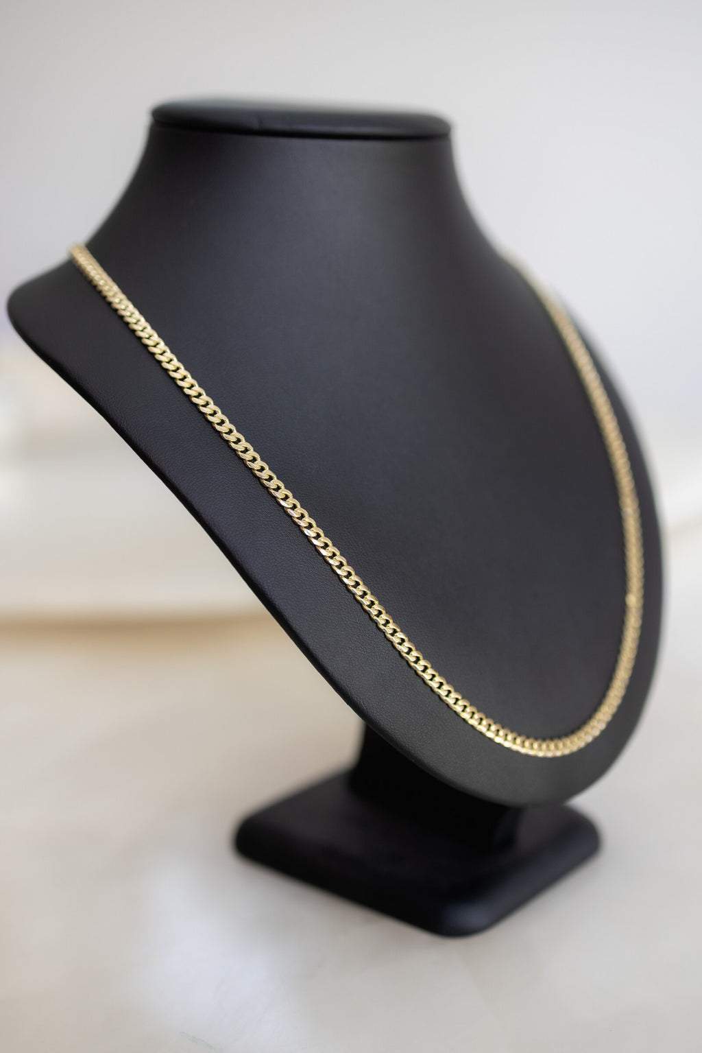4.1mm 9ct yellow gold handmade Cuban link chain on an angled display bust
