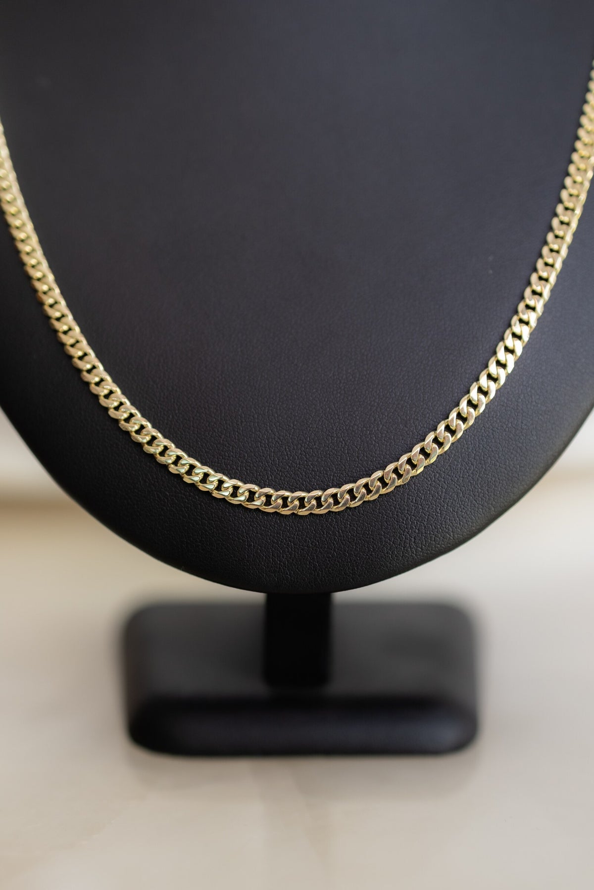 Brightly polished 4.1mm handmade Cuban link chain in 9ct yellow gold, side view