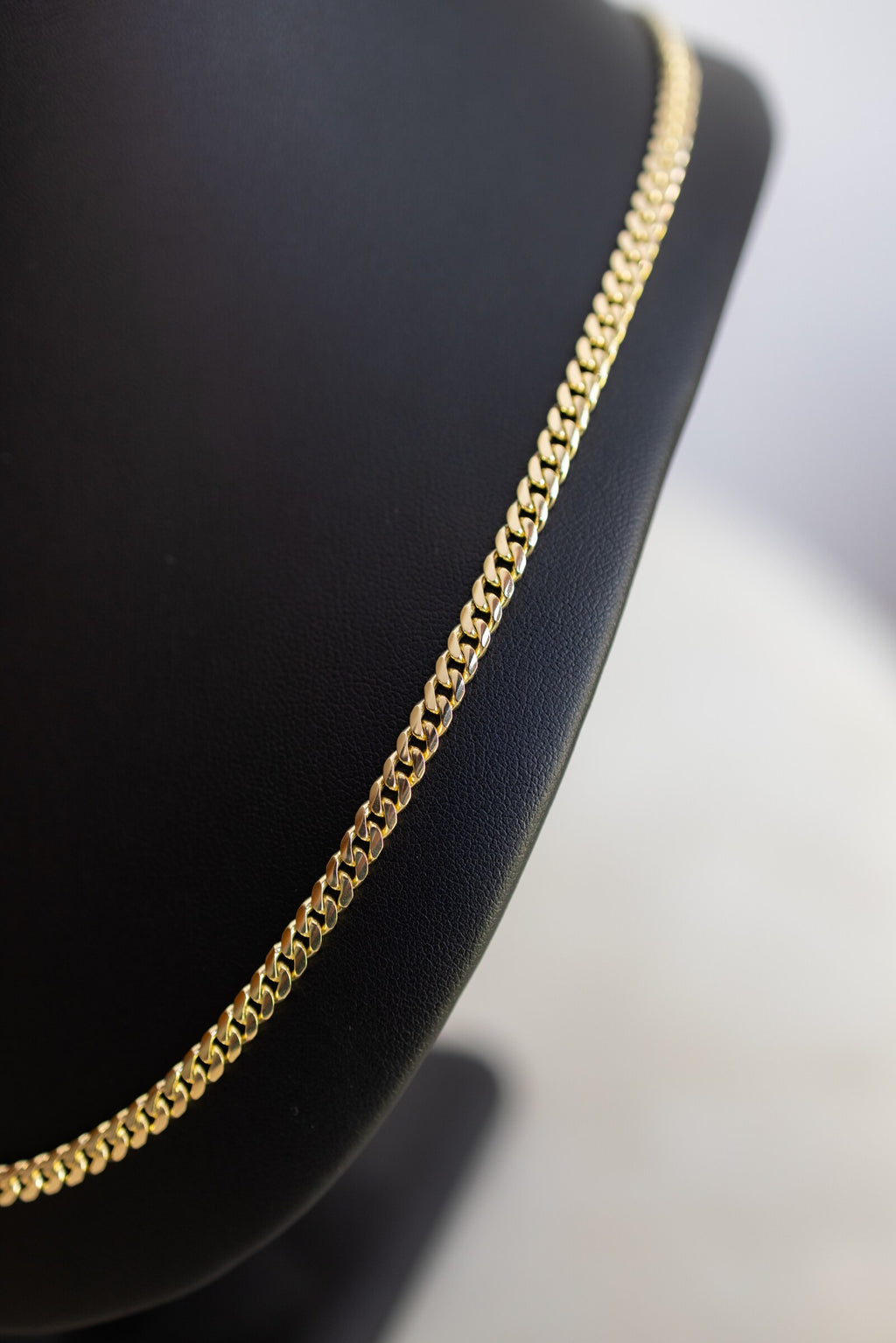 The 4.4mm handmade Cuban link chain in 9ct yellow gold, close detail of the curb links
