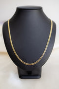 Handmade 4mm Cuban link chain in 9ct yellow gold on a display bust, front view